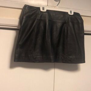 Black leather fully lined mini skirt.